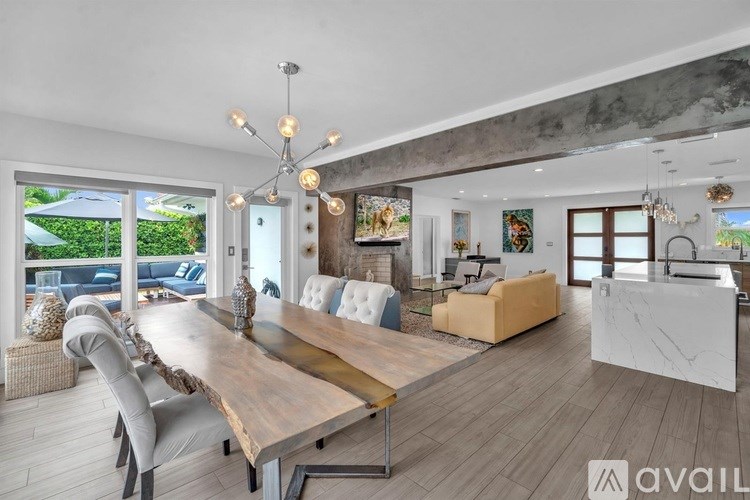 A modern dining room with a long wooden table and chairs.