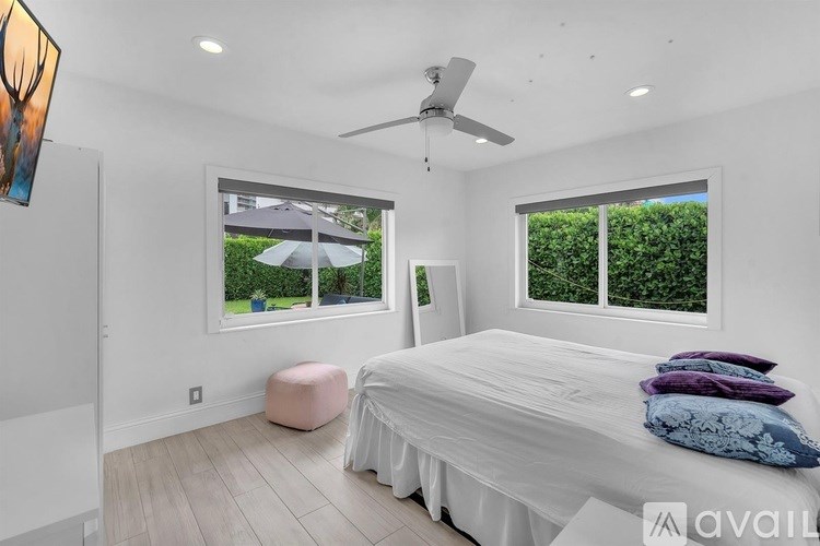 A bedroom with a large bed and a ceiling fan.