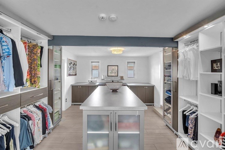 A spacious walk-in closet with a kitchen area in the middle.