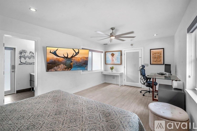 A bedroom with a large bed and a painting of a deer on the wall.