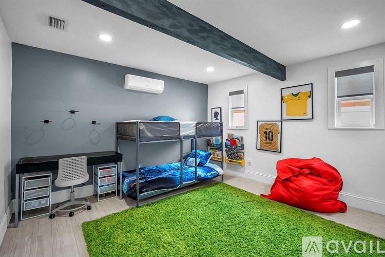 A room with a bunk bed, desk, and chair.