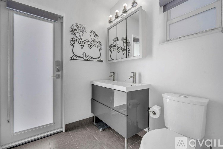 A bathroom with a sink, toilet, and mirror.