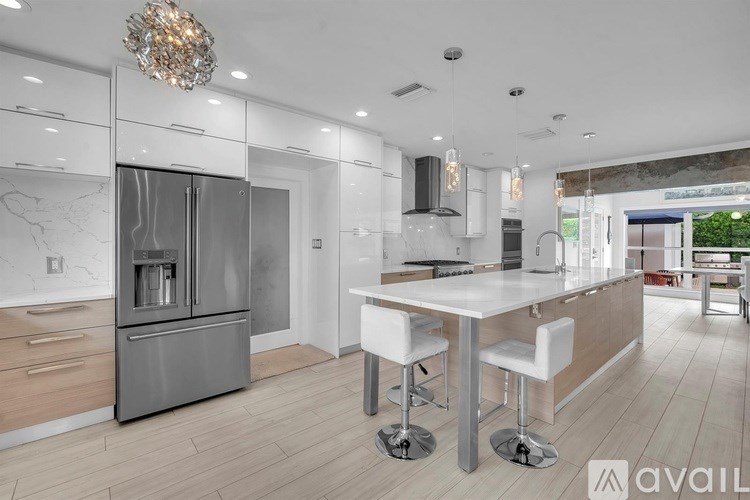 A modern kitchen with a large island and stainless steel appliances.
