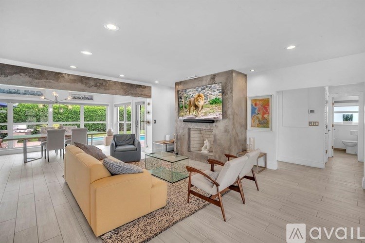 A living room with a sofa, chairs, and a television.