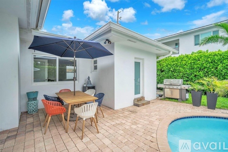 A patio with a table and chairs and a pool.