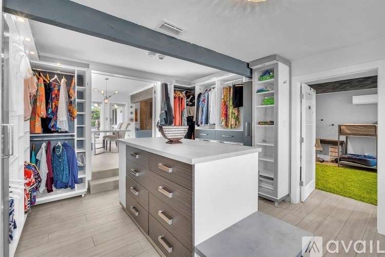 A spacious walk-in closet with a white counter and drawers.