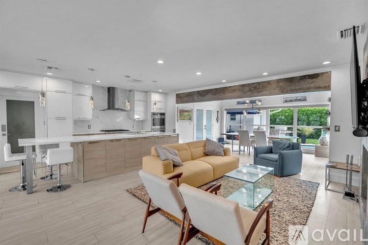 A modern kitchen with a dining area and a living room.