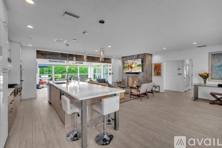 A spacious kitchen with a large island and bar stools.