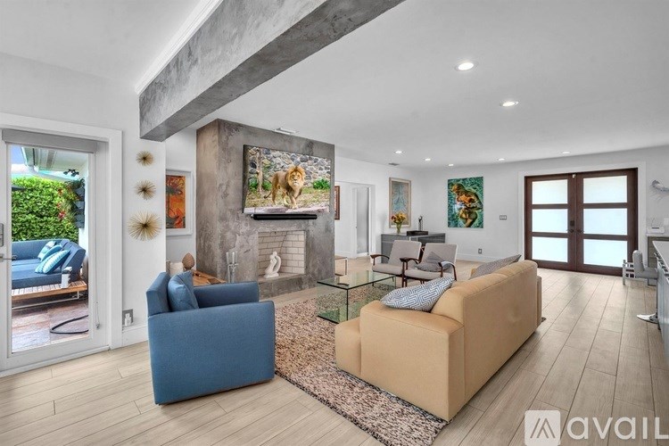 A living room with a blue couch, a tan couch, and a glass coffee table.