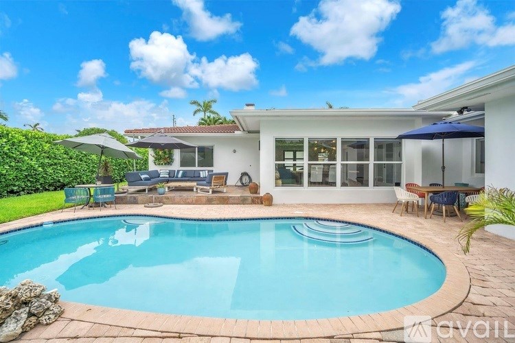 A swimming pool in a backyard with a house in the background.