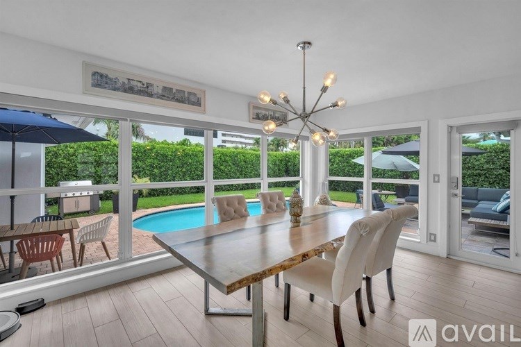 A dining room with a pool in the backyard.
