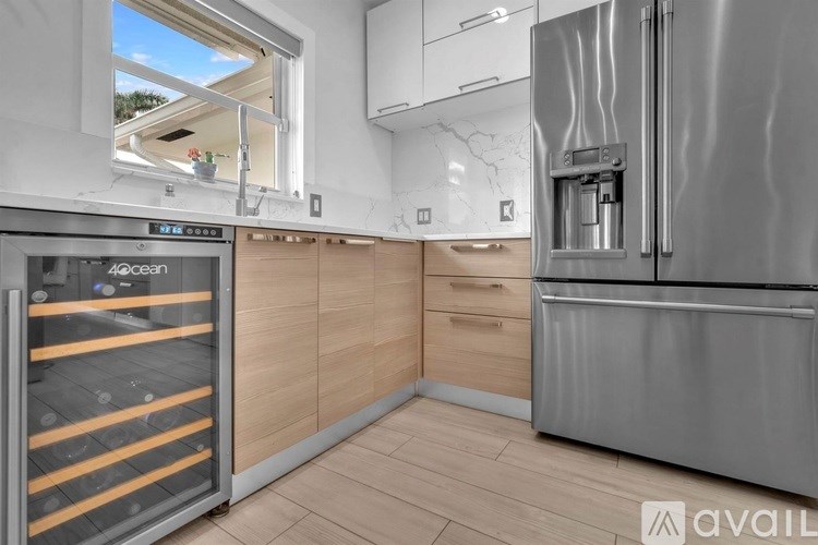 A modern kitchen with a stainless steel refrigerator and wooden cabinets.