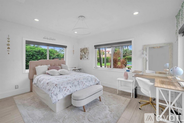 A bedroom with a large bed, desk, and chair.