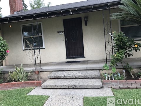 A house with a black door and a window with a metal grill.