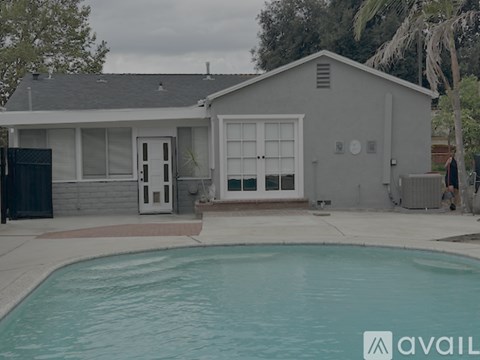 A house with a pool in front of it.