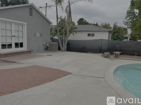 A backyard with a pool and a fence.