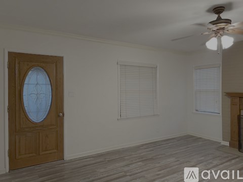 A room with a wooden door and a ceiling fan.