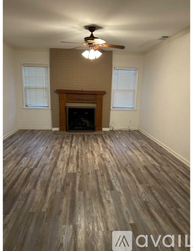 A room with a fireplace and wood flooring.