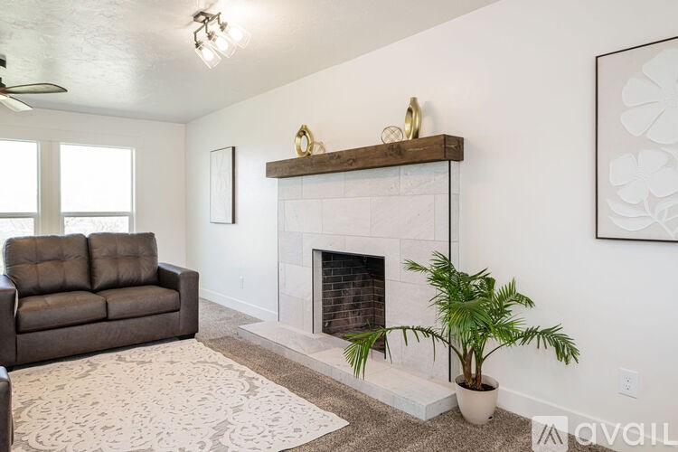 A living room with a fireplace and a plant.