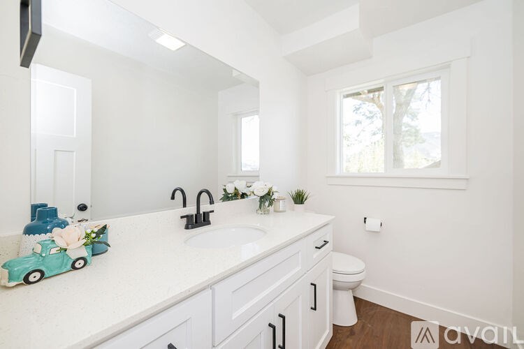 A white bathroom with a toy car on the counter.