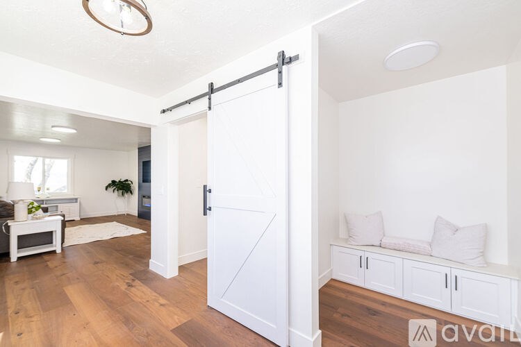 A white interior with a sliding door and a bench.