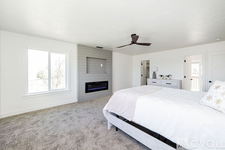 A bedroom with a large bed and a fireplace.