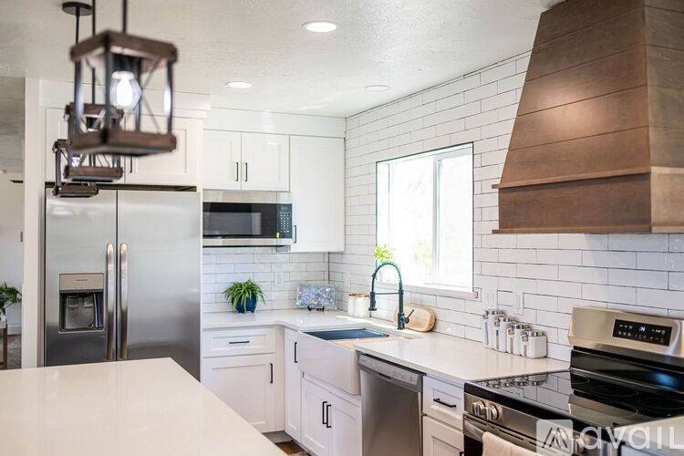 A modern kitchen with white cabinets and a stainless steel refrigerator.