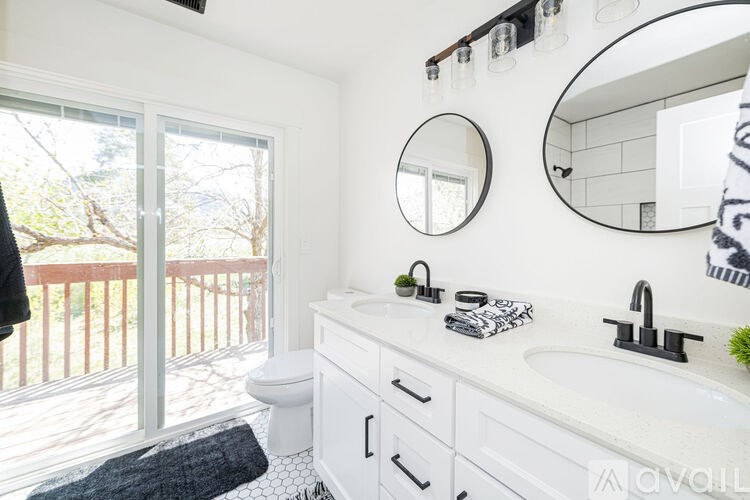 A bathroom with a white sink, toilet, and mirror.
