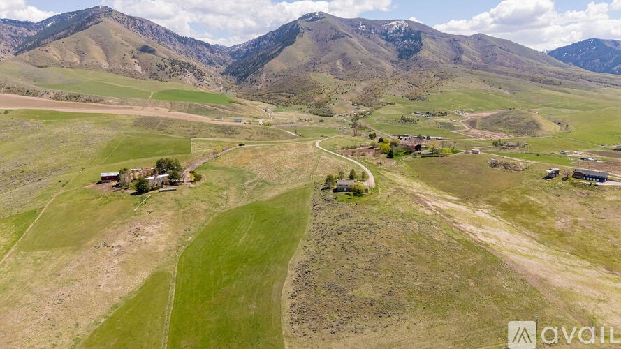 A rural landscape with a few buildings and a winding road.