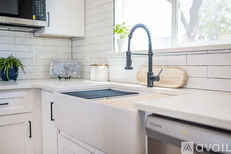 A kitchen with white cabinets and a black microwave above the stove.