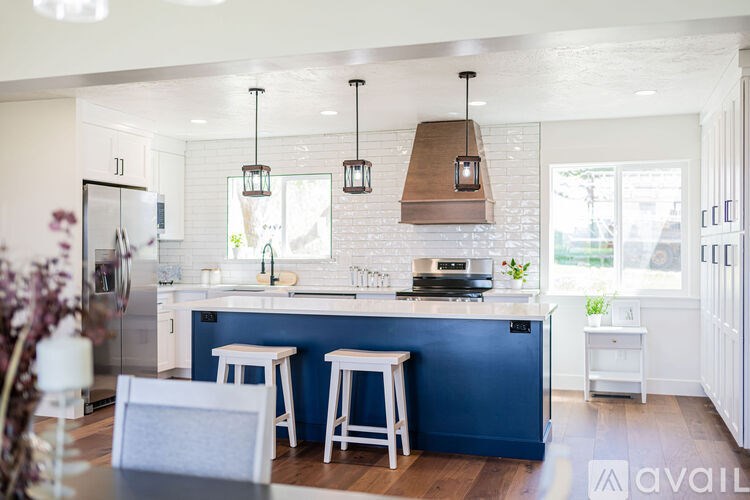 A kitchen with a blue island and white cabinets.