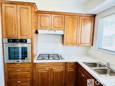 A kitchen with wooden cabinets and a white stove top.