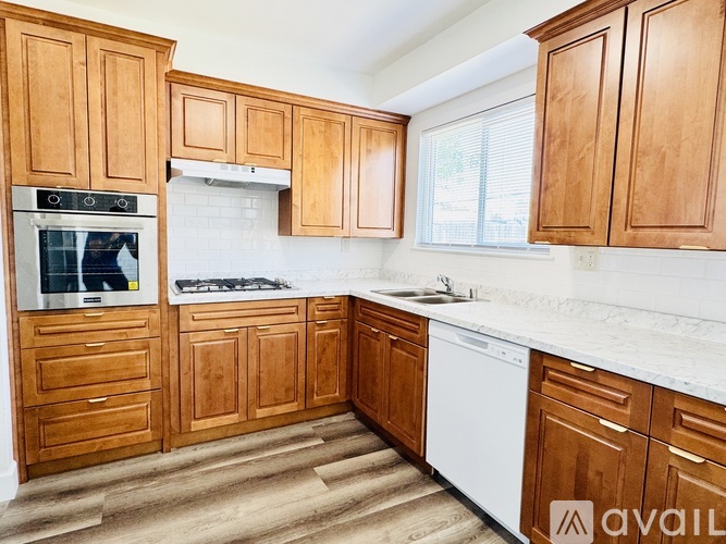 A kitchen with wooden cabinets and a white dishwasher.