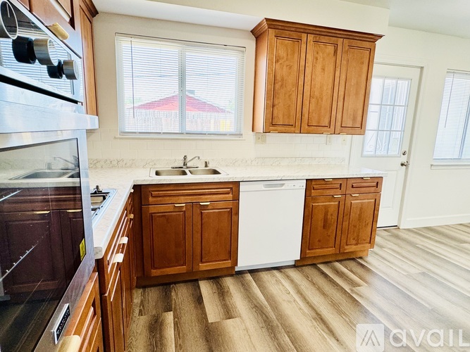A kitchen with wooden cabinets and a white dishwasher.