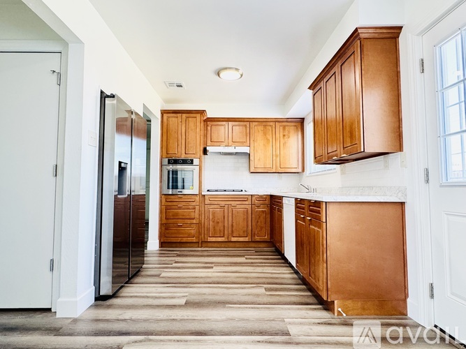 A kitchen with wooden cabinets and a refrigerator.