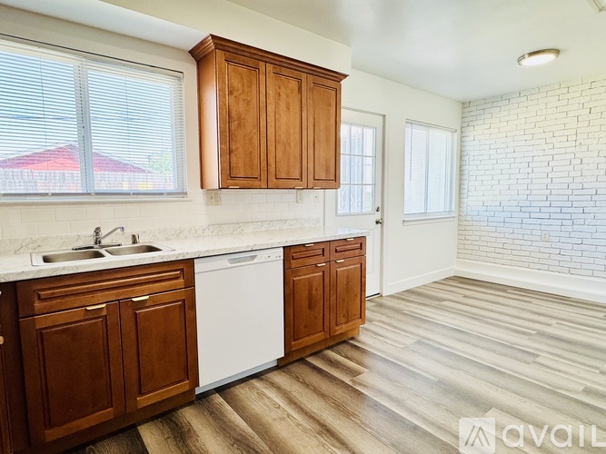 A kitchen with wooden cabinets and a white dishwasher.