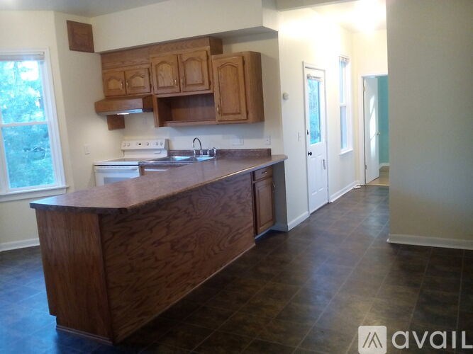 A kitchen with wooden cabinets and a wooden island.