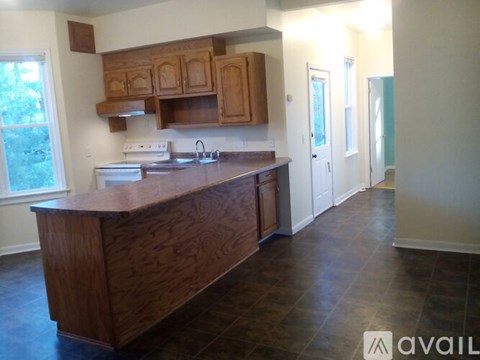 A kitchen with wooden cabinets and a wooden island.
