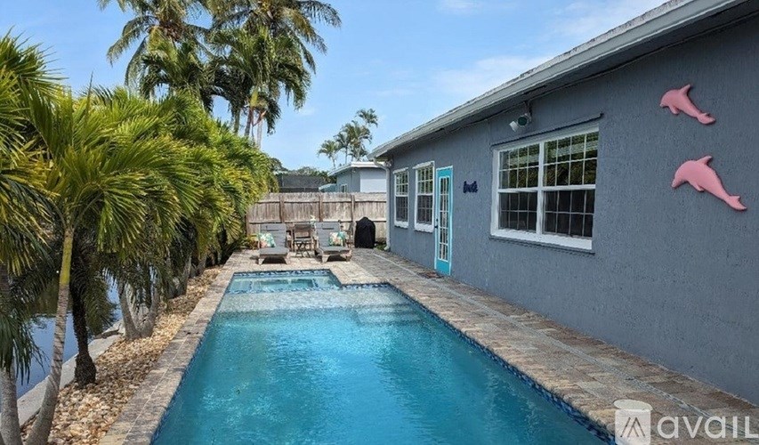 A pool in a backyard with a house and trees.