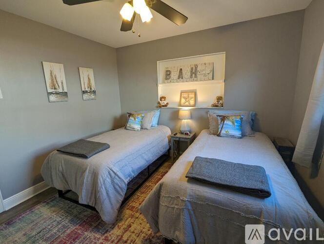 A bedroom with two beds and a ceiling fan.