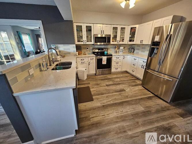 A kitchen with a white counter and stainless steel appliances.