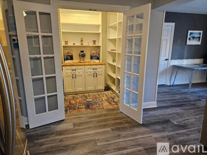 A kitchen with white cabinets and a rug on the floor.