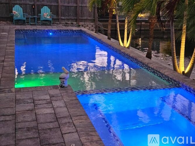 A pool with a person sitting on the edge.