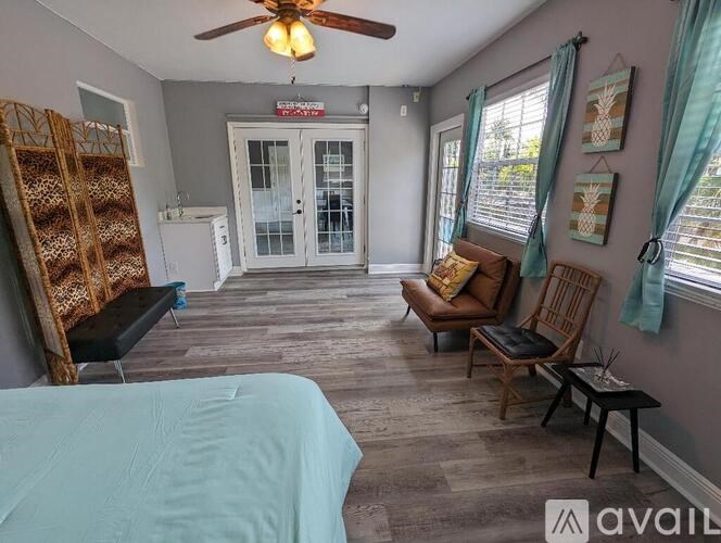 A bedroom with a bed, chair, and window.