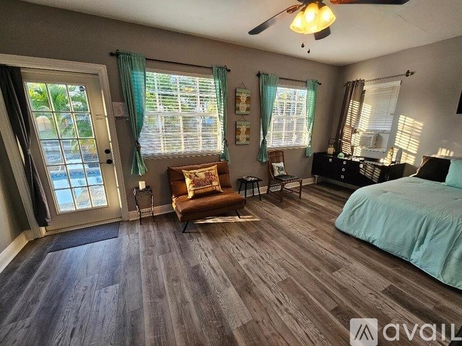 A bedroom with a bed, chair, and window.