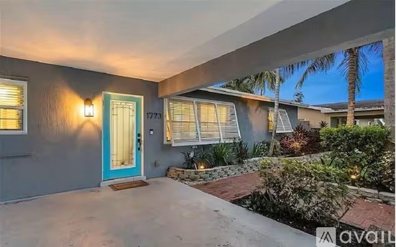 A house with a blue door and a number 1773 on the wall.