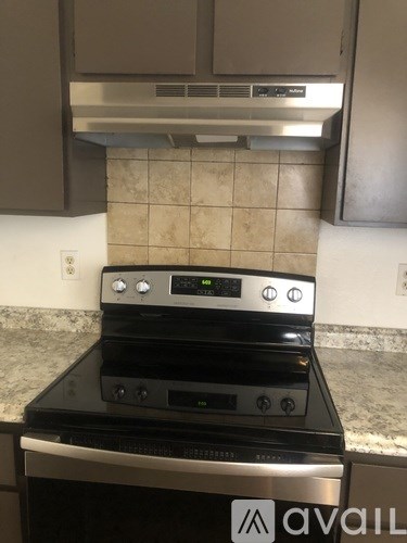 A stainless steel oven with a digital display is built into a kitchen counter.