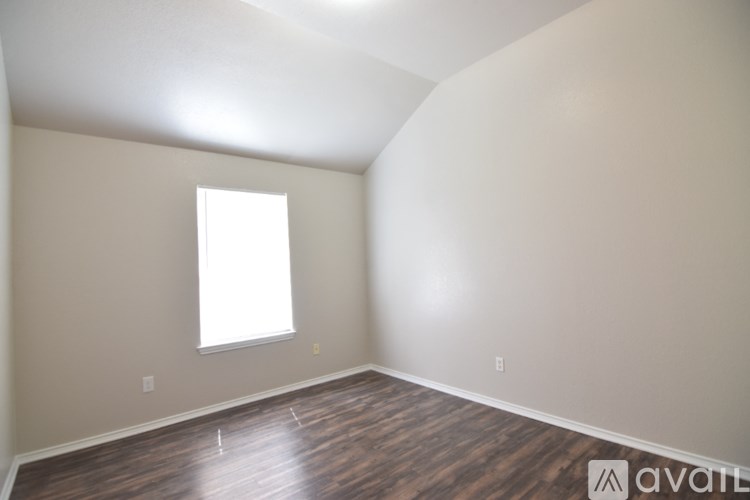 A room with a window and wooden flooring.