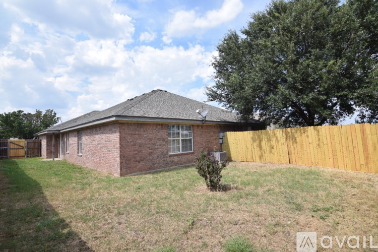 A house with a brown fence and a tree in front.