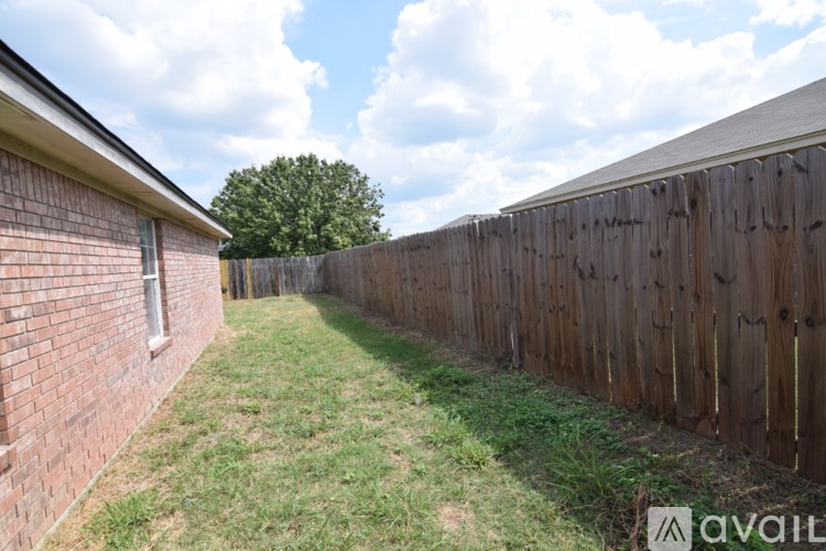 A backyard with a wooden fence and a grassy area.